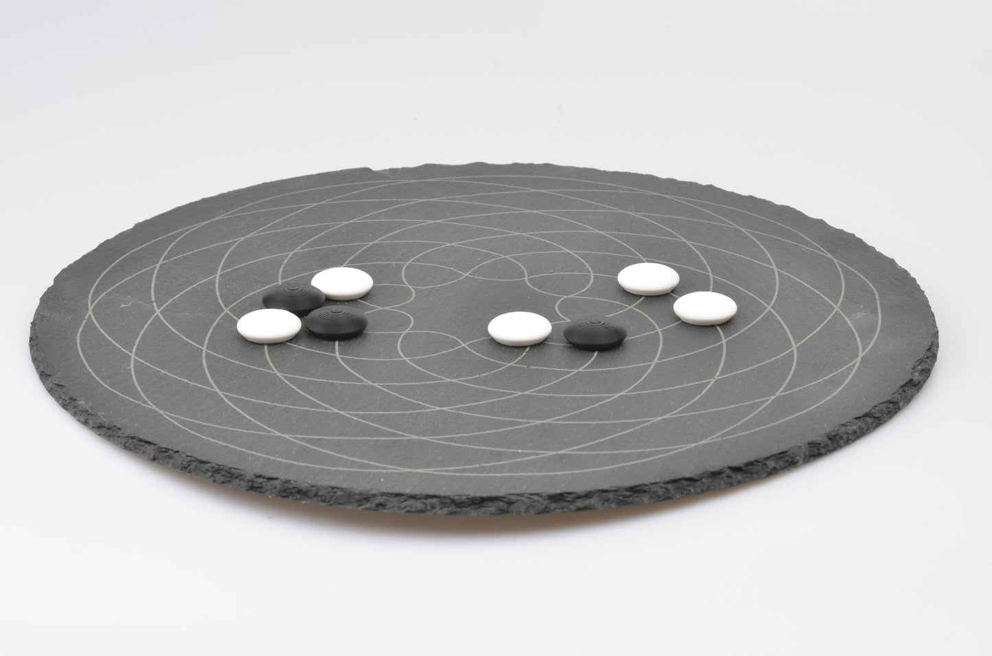 Go Strategie-Spiel Aufbau: Platzierte Spielsteine auf dem runden Design-Brett in Spielsituation.