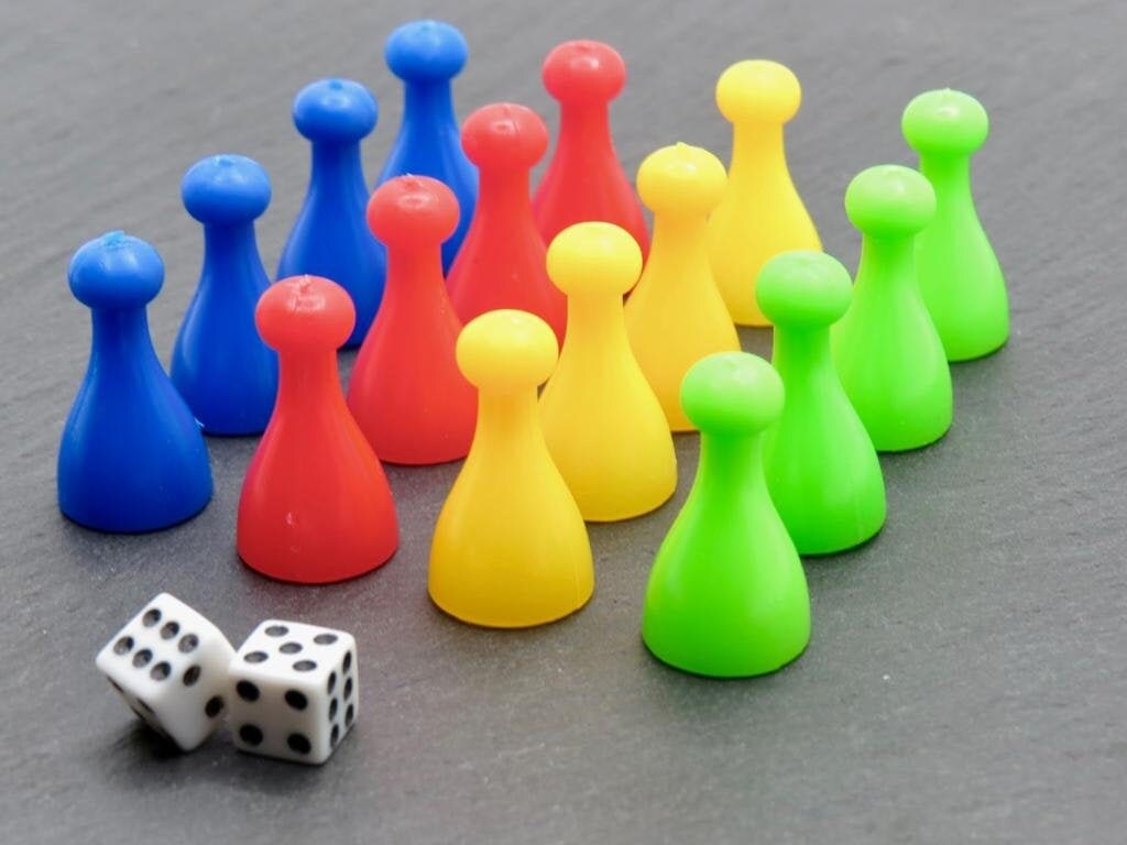Ludo Spielfiguren Set: Robuste Pöppel in Blau, Rot, Gelb und Grün mit Würfel auf Schieferplatte.