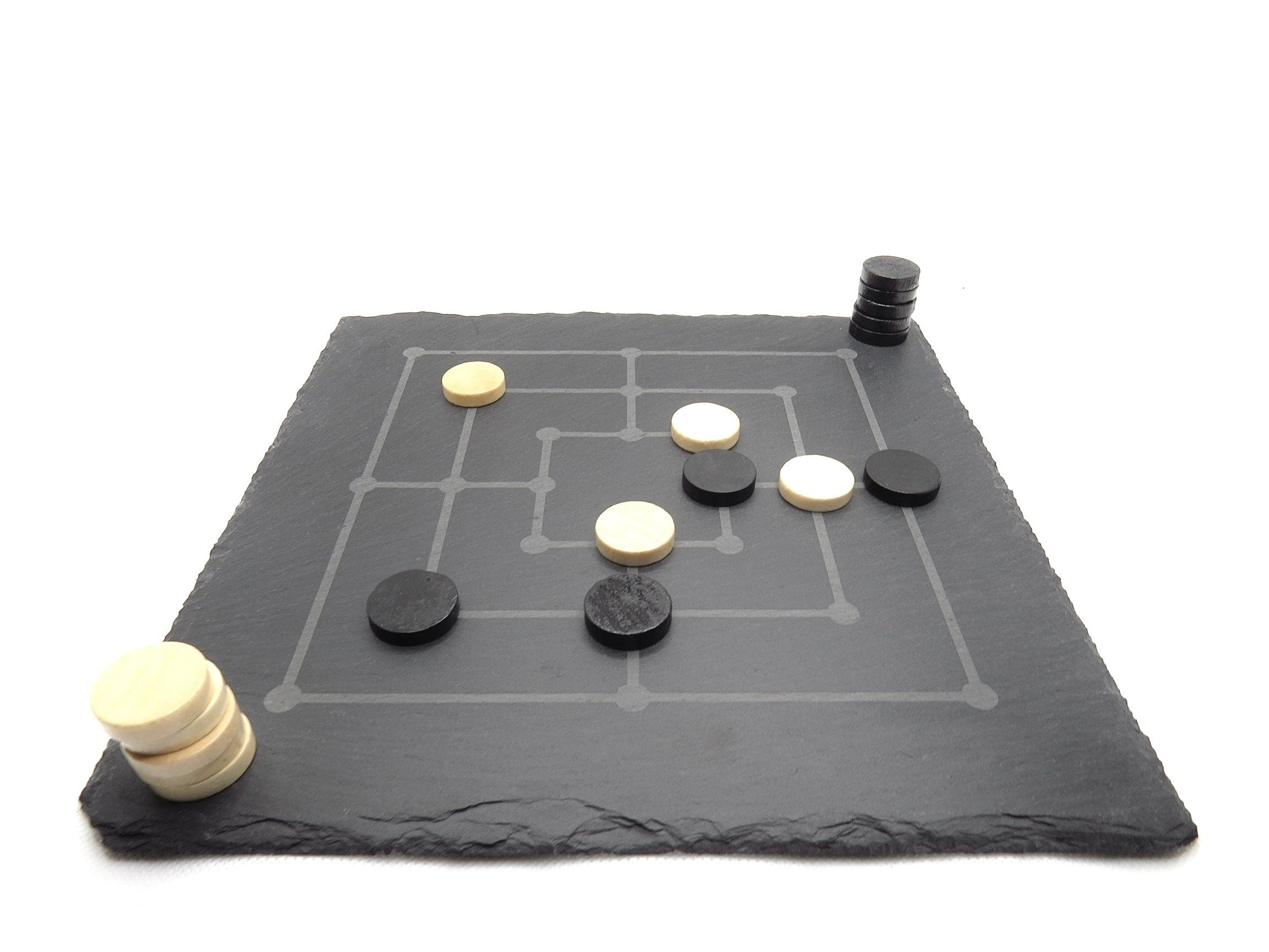 Mühle Spiel Set aus Naturschiefer: Lasergraviertes Brett mit schwarzen und weißen Spielsteinen im edlen Design.