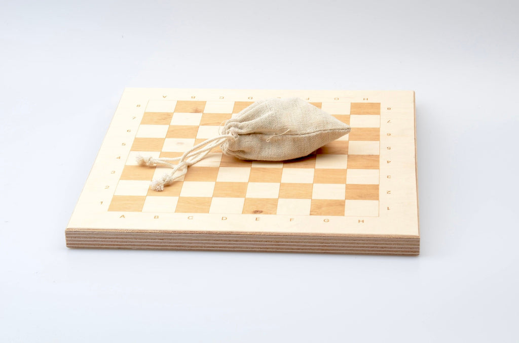 Zubehör für Holzschach: Praktischer Leinenbeutel zur Aufbewahrung der Figuren auf dem hellen Spielbrett.