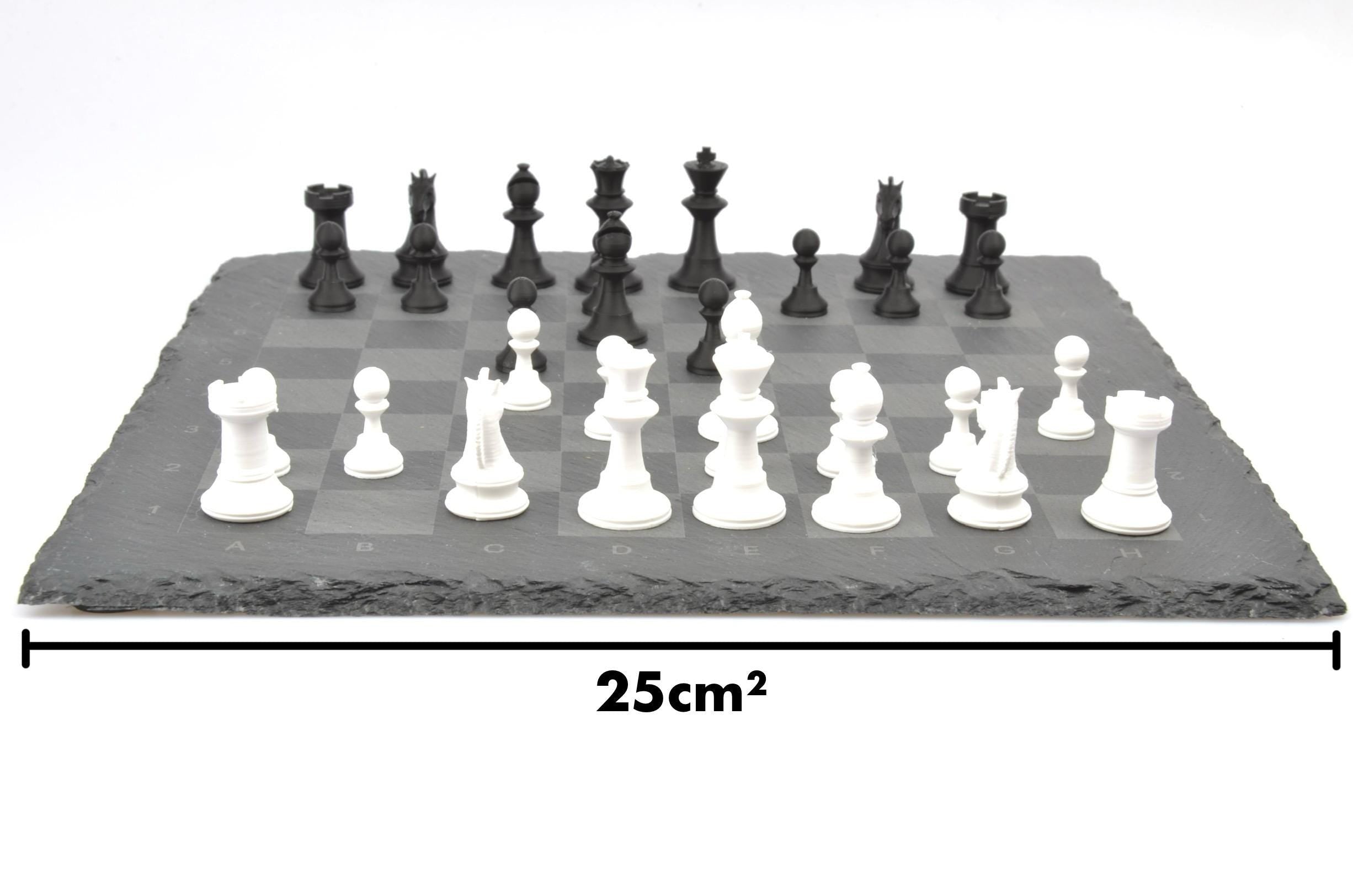 Maße des kompakten Schachspiels: 25 cm breites Brett aus Naturschiefer mit aufgestellten Figuren in Schwarz und Weiß.
