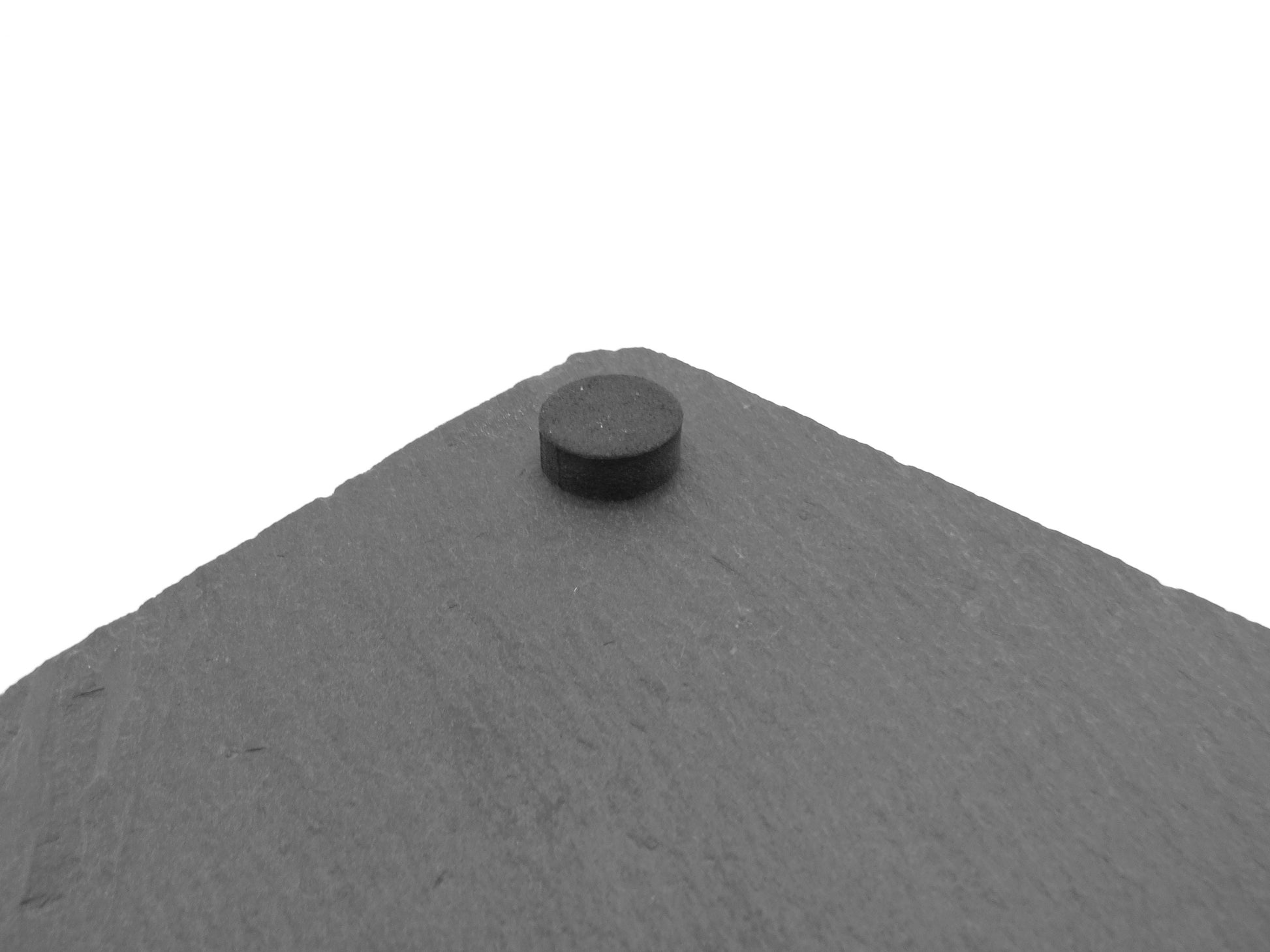 Detailansicht der Schieferstruktur: Natürliche Bruchkanten und graue Oberfläche des Mühle-Spielbretts. Rubber pads.